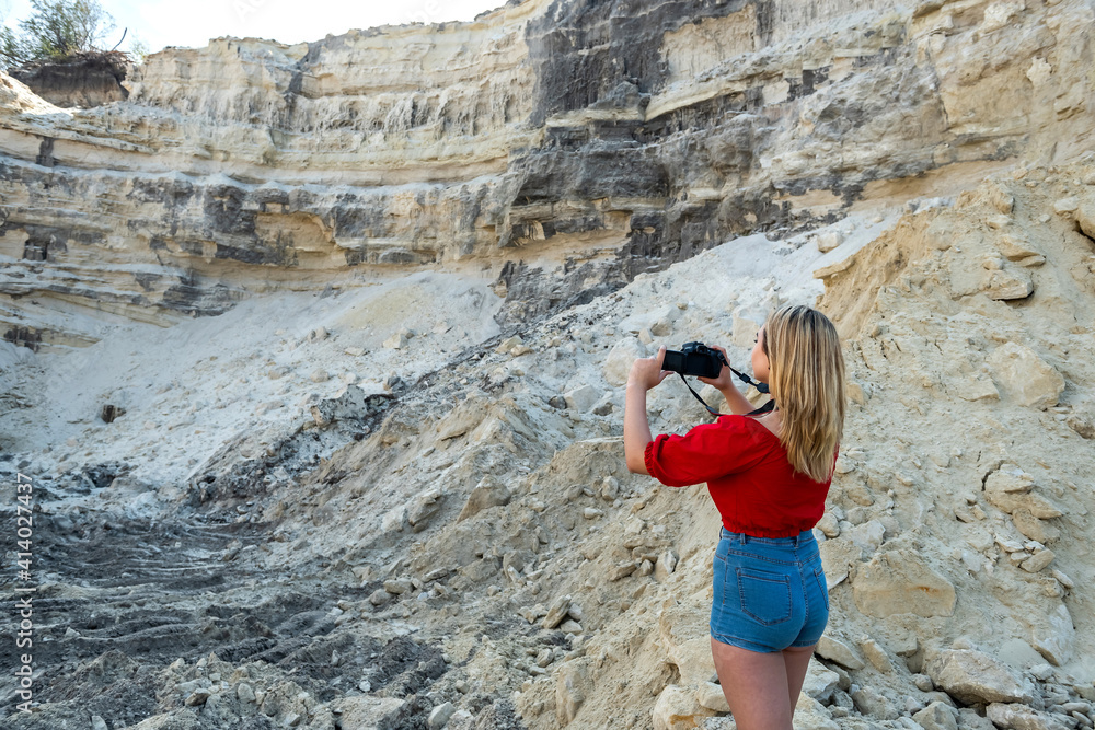Fototapeta premium stylish young woman walking in sand rock in hot summer day
