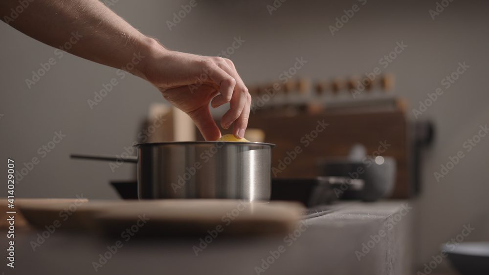 man hand put fettuccine into boiling water in saucepan man hand put fettuccine into boiling water in saucepan