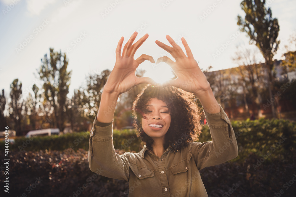 Photo of attractive positive wavy hairdo person fingers show heart figure above head good mood vacation free time outdoors Photo of attractive positive wavy hairdo person fingers show heart figure above head good mood vacation free time outdoors