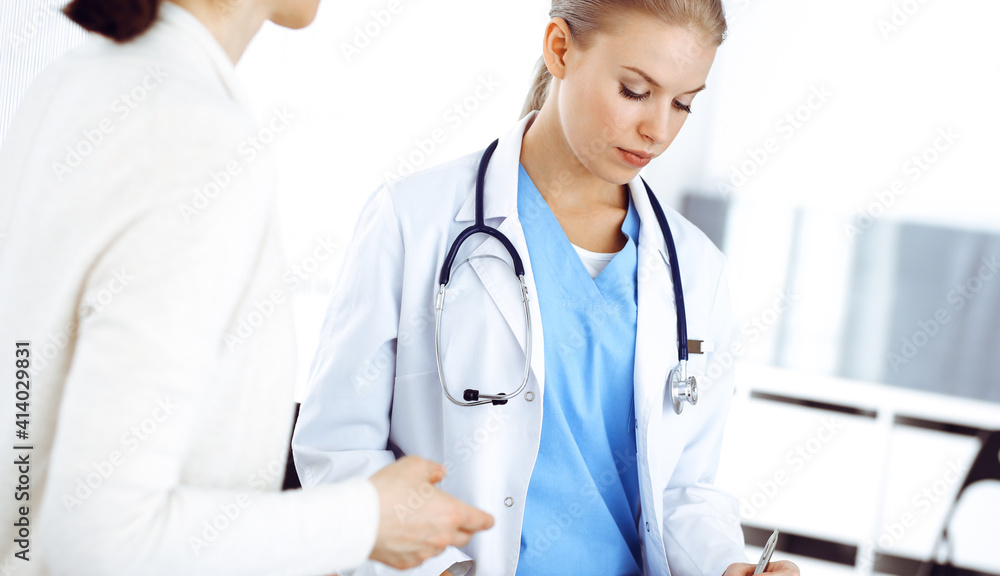 Woman - doctor consults her female patient while using clipboard and medication history record. Medicine concept Woman - doctor consults her female patient while using clipboard and medication history record. Medicine concept