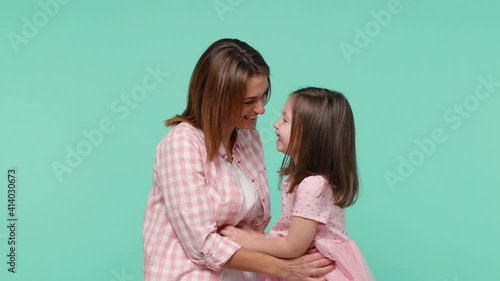 Woman in pink clothes have fun with cute child baby girl 5-6 years old. Mommy tickle little kid daughter rejoice joy gladden isolated on pastel blue background studio. Mother's Day love family concept