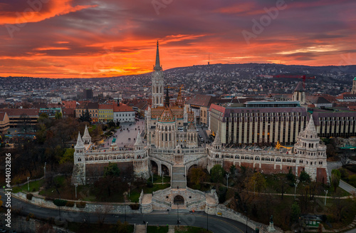 Budapest, Hungary - Aerial view of a dramatic golden sunset behind the famous Fisherman's Bastion (Halaszbastya) and Matthias Church on a winter afternoon. Festive lights and christmas decoration