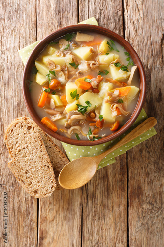 Bramboracka Czech Soup with Wild Forrest Mushrooms served with bread closeup in the plate on the table. Vertical top view from above photo