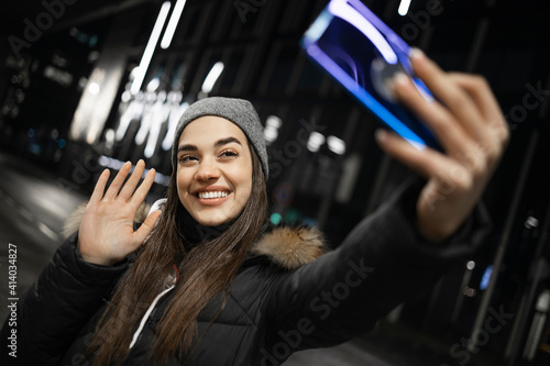 A beautiful girl waving at a smartphone camera