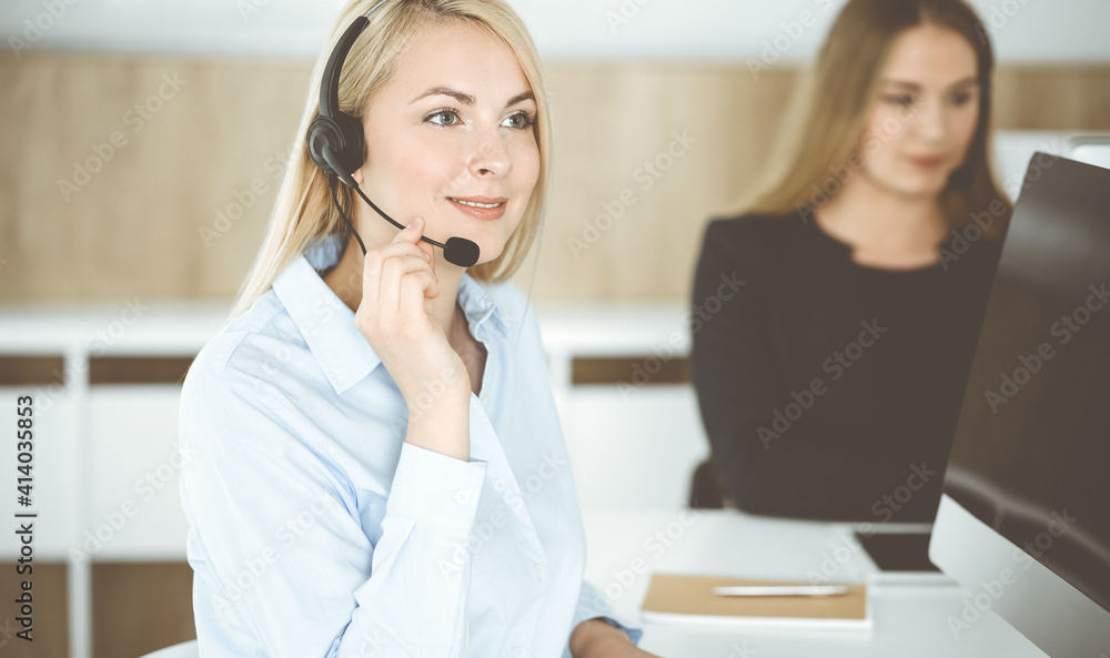 Blonde business woman sitting and communicated by headset in call center office. Concept of telesales business Blonde business woman sitting and communicated by headset in call center office. Concept of telesales business