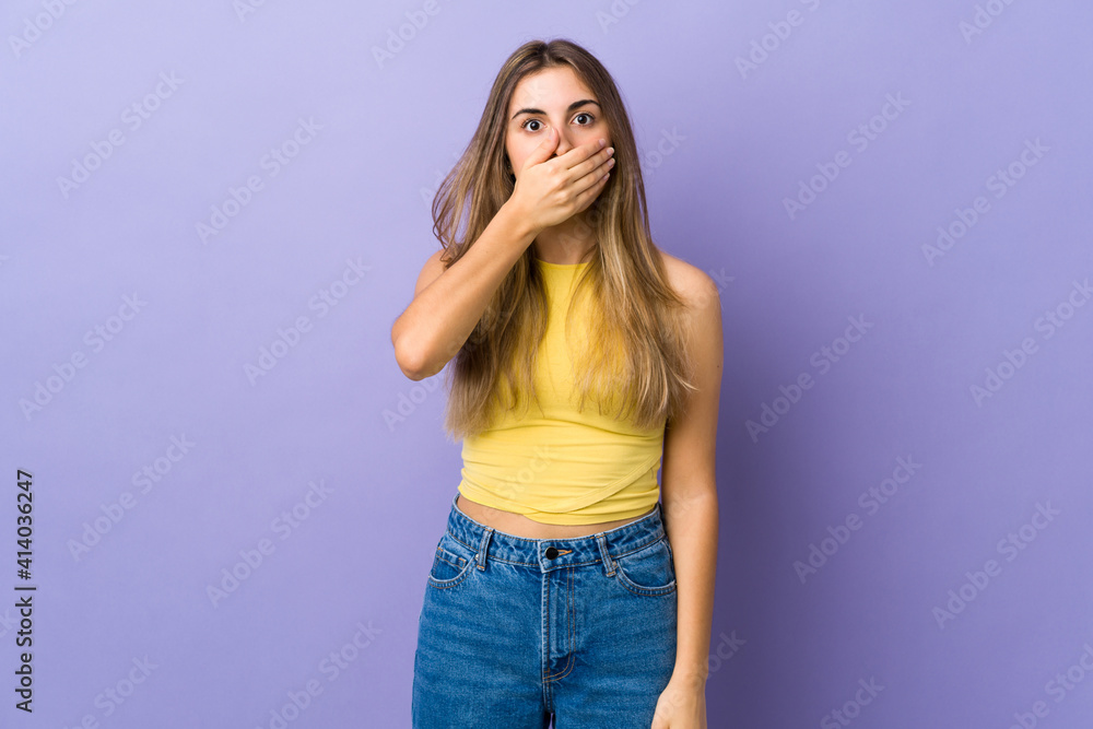 Young woman over isolated purple background covering mouth with hand Young woman over isolated purple background covering mouth with hand