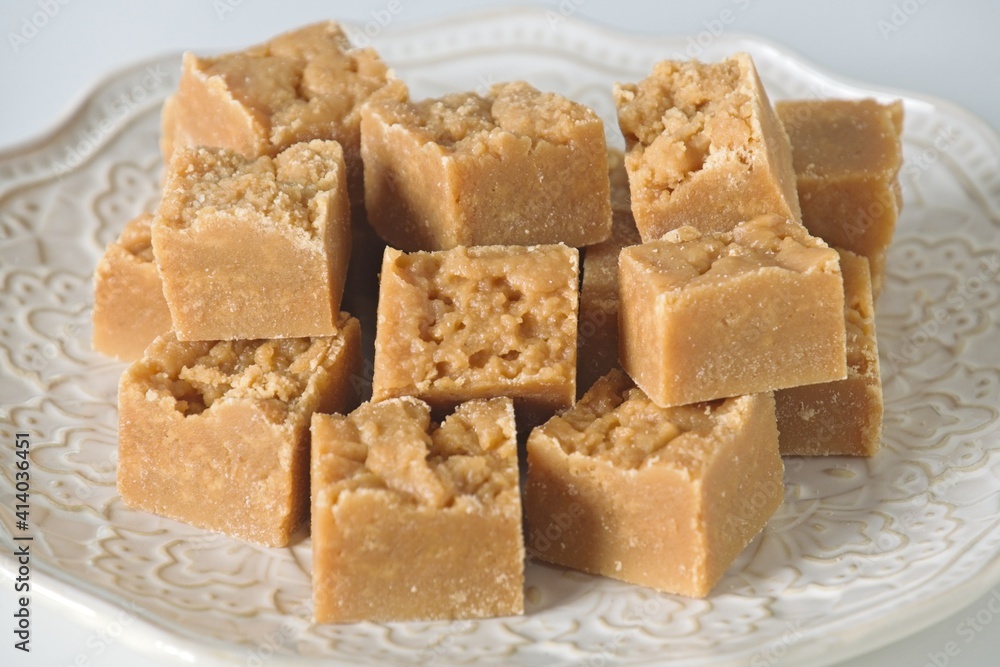 Homemade fudge cut into cubes on plate on white kitchen counter Homemade fudge cut into cubes on plate on white kitchen counter