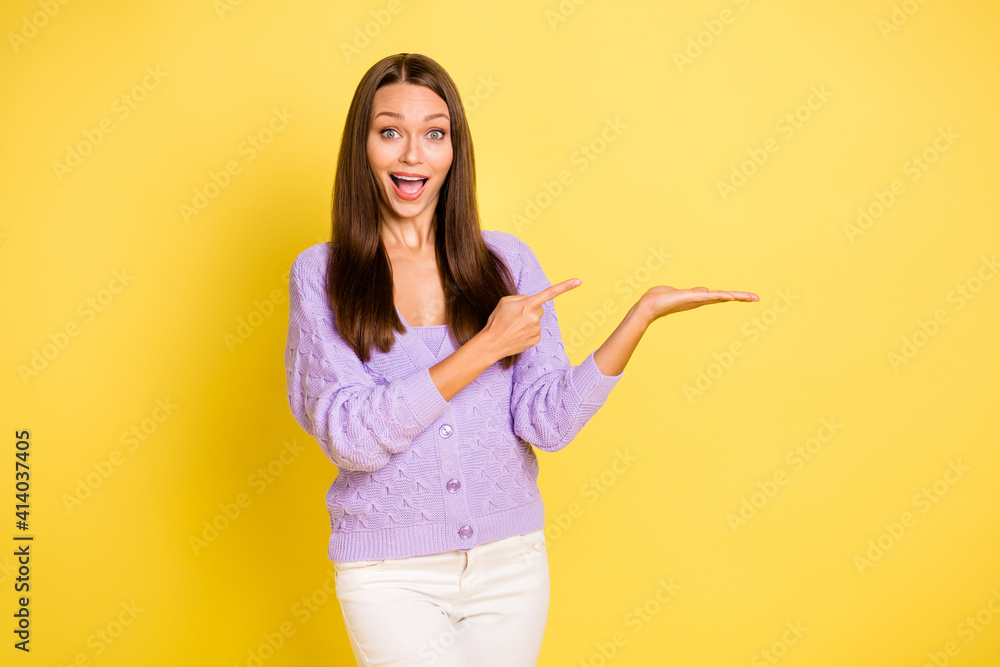 Portrait of pretty amazed cheerful girl holding on palm ad copy space look idea solution isolated over bright yellow color background Portrait of pretty amazed cheerful girl holding on palm ad copy space look idea solution isolated over bright yellow color background