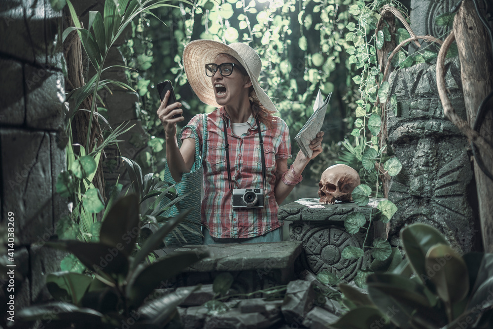 Angry woman shouting at the phone in the jungle