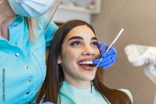 Portrait of female patient having treatment at dentist.Dentist examining a patient s teeth in dentist office.