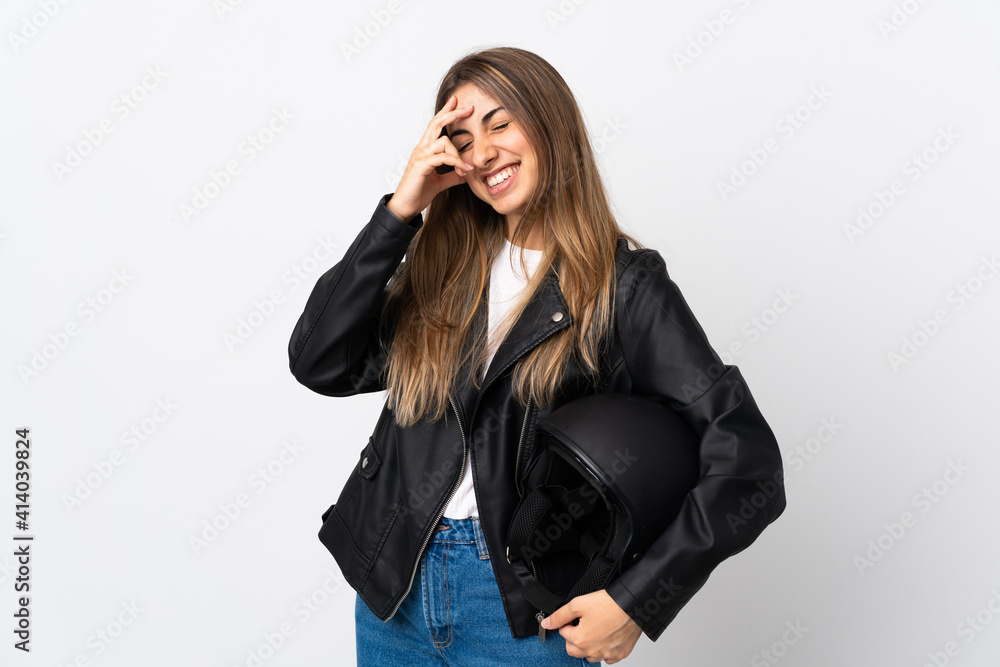 Young Woman holding a motorcycle helmet over isolated white background laughing Young Woman holding a motorcycle helmet over isolated white background laughing