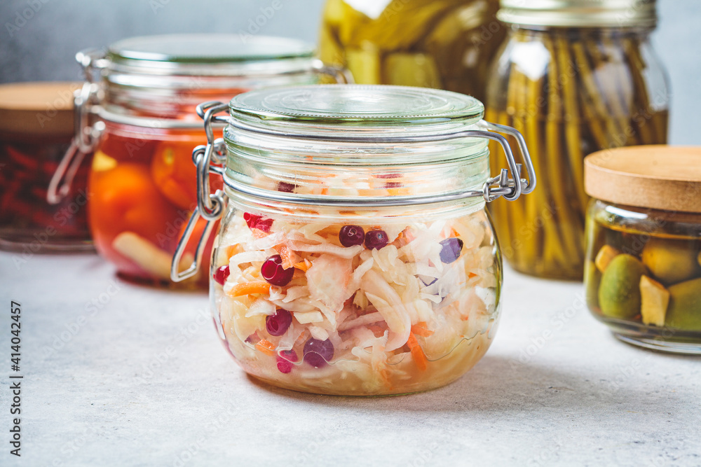 Sauerkraut with cranberries in a glass jar. Homemade pickled or fermented vegetables. Sauerkraut with cranberries in a glass jar. Homemade pickled or fermented vegetables.
