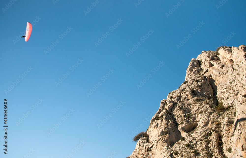 Red paraglider flying in Spain during sunny autumn day Red paraglider flying in Spain during sunny autumn day