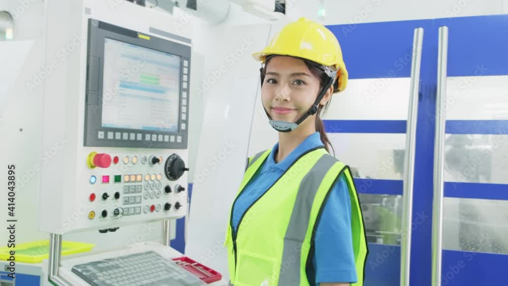 Asian female worker working on machine in production room of factory. Asian female worker working on machine in production room of factory.