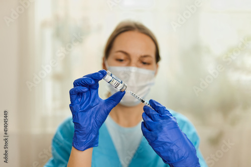 Doctor, nurse hand in blue gloves holding coronavirus covid-19 vaccine