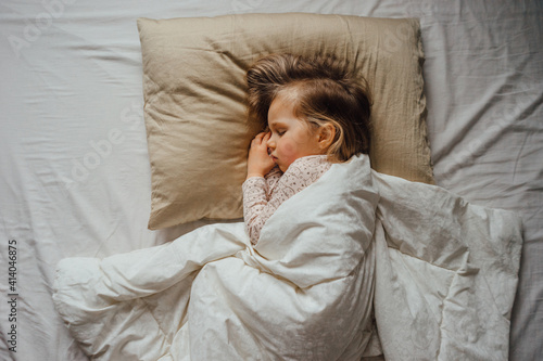 Little girl sleeping in bed at home, top view