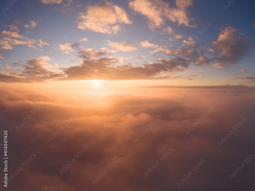 view from an airplane on a beautiful saturated sunrise above the clouds view from an airplane on a beautiful saturated sunrise above the clouds