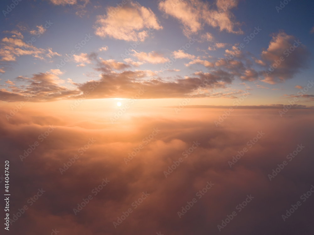 view from an airplane on a beautiful saturated sunrise above the clouds