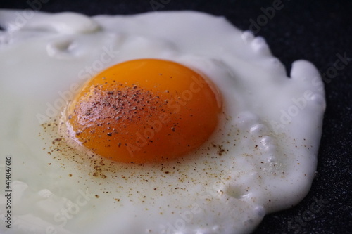 Fried eggs on the pan and peppered on top