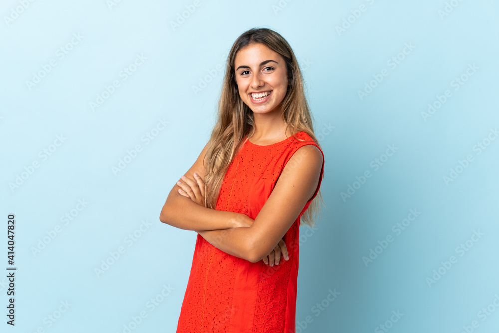 Young hispanic woman over isolated blue background with arms crossed and looking forward Young hispanic woman over isolated blue background with arms crossed and looking forward