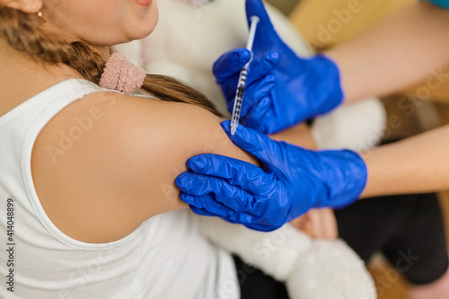 Positive pediatrician doctor vaccinating or inoculating preschool child
