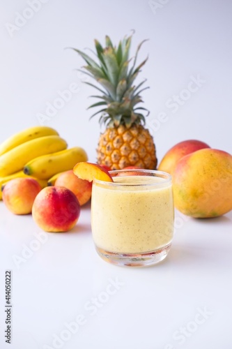 Fototapeta Naklejka Na Ścianę i Meble -  Healthy fruit smoothie in glass in front of fresh fruit