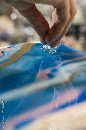 at the workshop on creating fluid art transparent crystals are poured onto the blue resin art picture photo