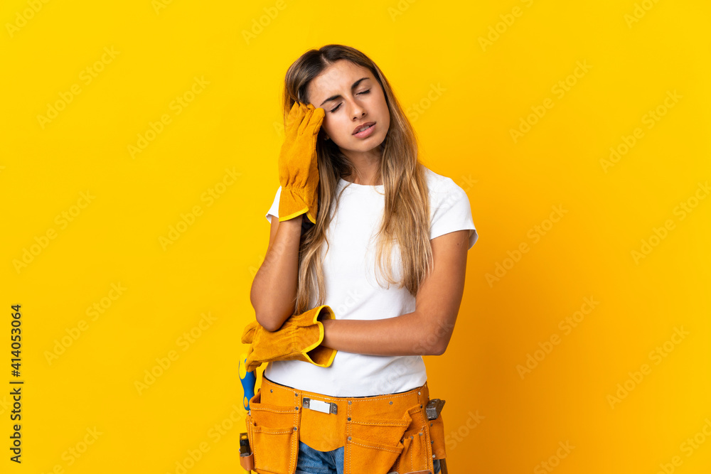 Young hispanic electrician woman over isolated yellow wall with headache Young hispanic electrician woman over isolated yellow wall with headache