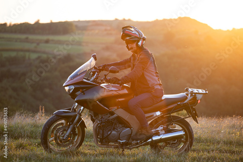 Fototapeta Naklejka Na Ścianę i Meble -  Man on his motorbike riding into sunset