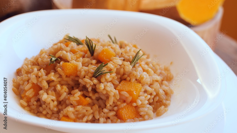 Pumpkin risotto, recipe with rice and pumpkin on rustic table with ingredients. Autumn and Halloween recipe.