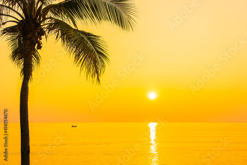 Coconut palm tree around sea beach ocean at sunset or sunrise