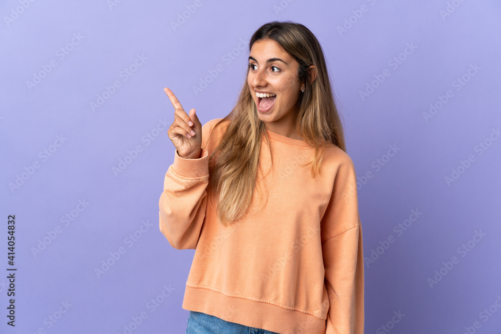 Fototapeta premium Young hispanic woman over isolated purple background intending to realizes the solution while lifting a finger up