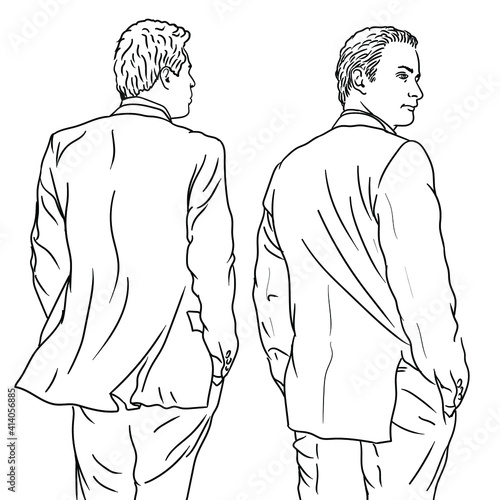 A young man in a classic suit stands with his back turned.