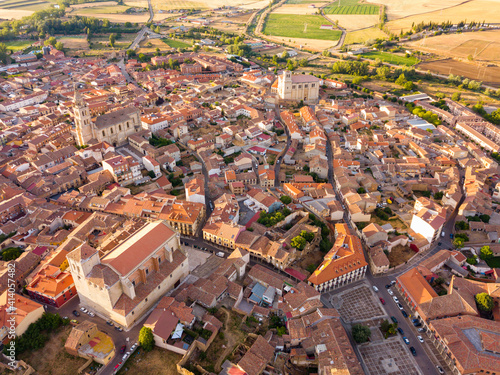 Aerial view of small Spanish city of Medina de Rioseco on background of picturesque landscape with green fields