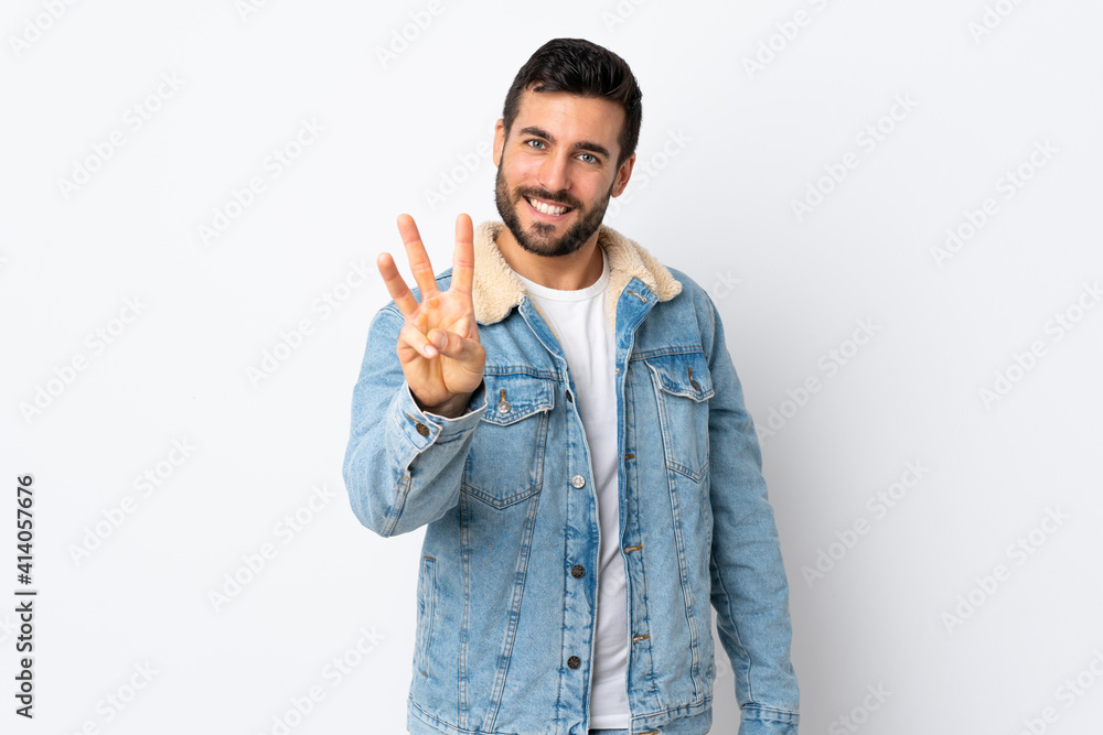 Young handsome man with beard isolated on white background happy and counting three with fingers Young handsome man with beard isolated on white background happy and counting three with fingers