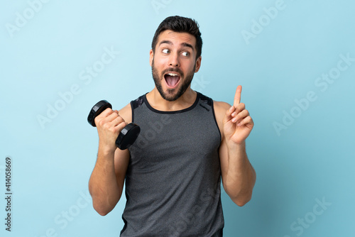 Young sport man with beard making weightlifting intending to realizes the solution while lifting a finger up