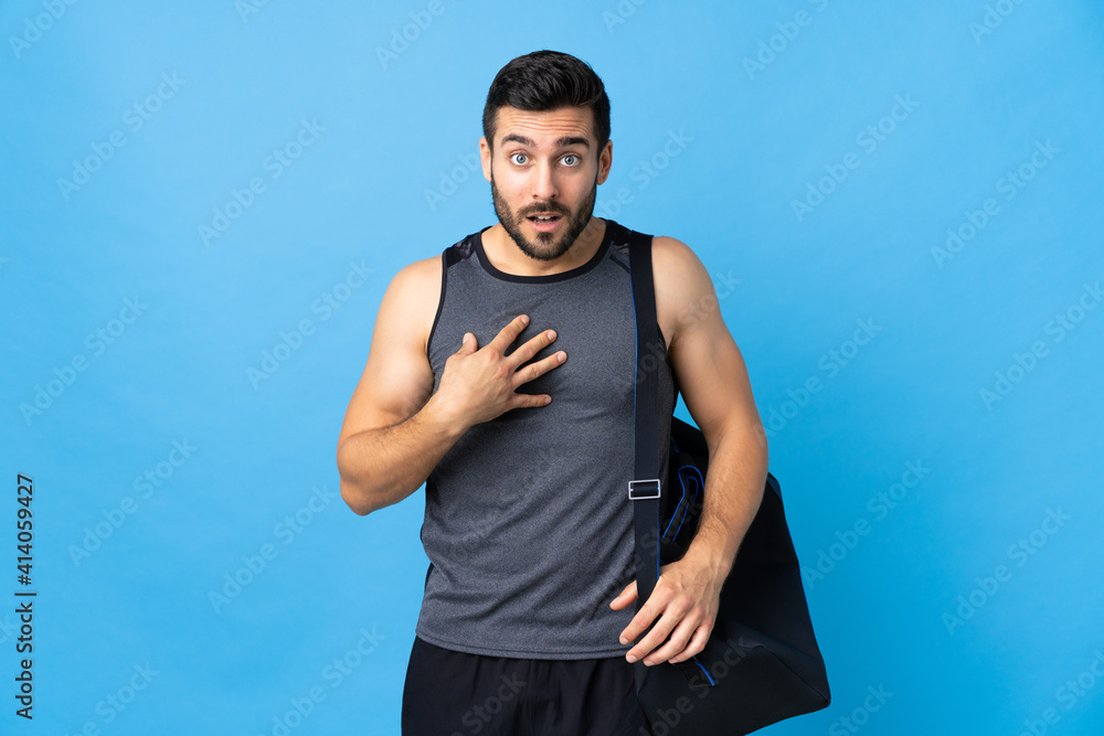 Young sport man with sport bag isolated on blue background pointing to oneself Young sport man with sport bag isolated on blue background pointing to oneself