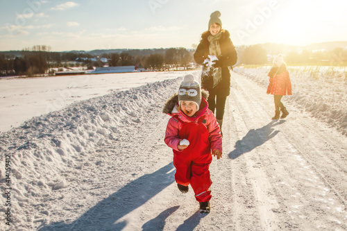 Mutter mit Kindern toben im Schnee photo