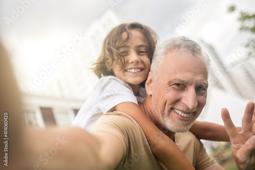 A dad and a son making photos and smiling