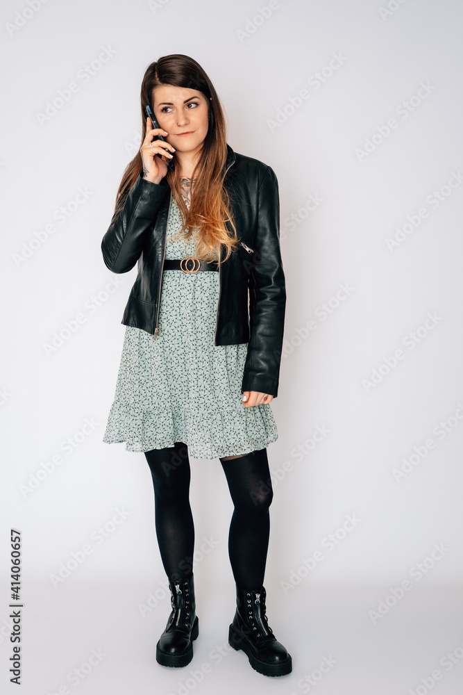 Frau telefoniert, grünes Blumenkleid, schwarze Lederjacke, braune lange Haare, feundlich, modern, Handy Frau telefoniert, grünes Blumenkleid, schwarze Lederjacke, braune lange Haare, feundlich, modern, Handy