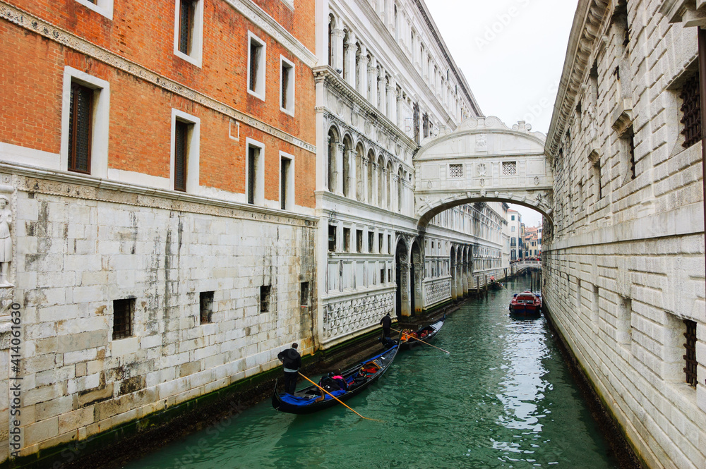 Gondolas floating on canal towards Bridge of Sighs (Ponte dei Sospiri). Venice, Italy. Perspective. 