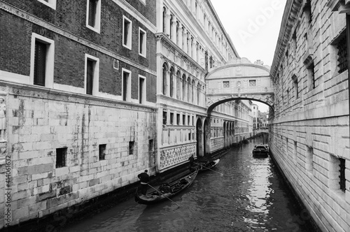 Gondolas floating on canal towards Bridge of Sighs (Ponte dei Sospiri). Venice, Italy. Perspective. Black white historic photo.