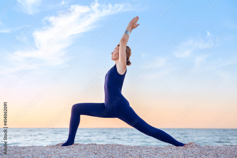 Woman practicing yoga in a sea background.
