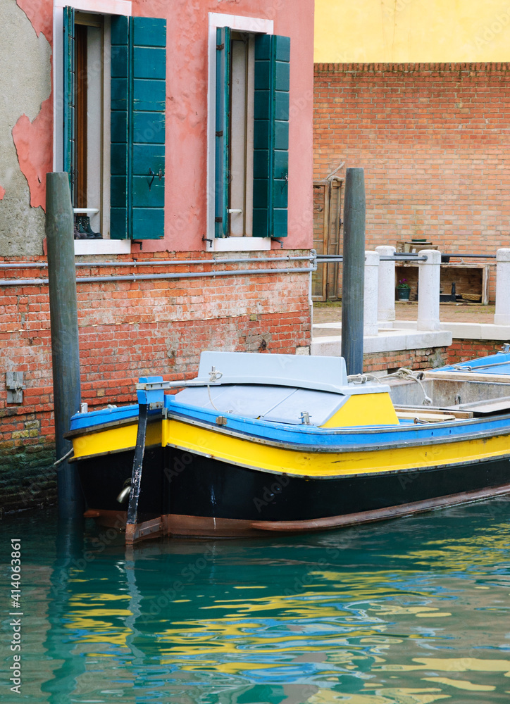 Everyday life of non touristic Venice. Boats, buildings, reflection canal water.