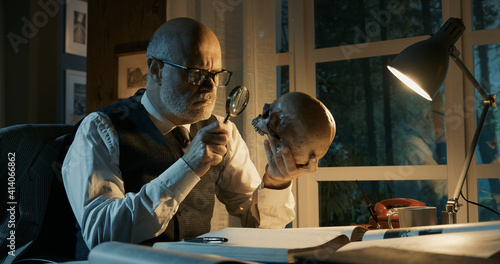 Canvastavla Professor sitting at desk and checking a human skull