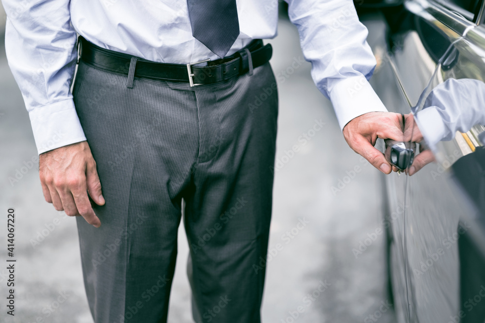 Businessman opening a car door