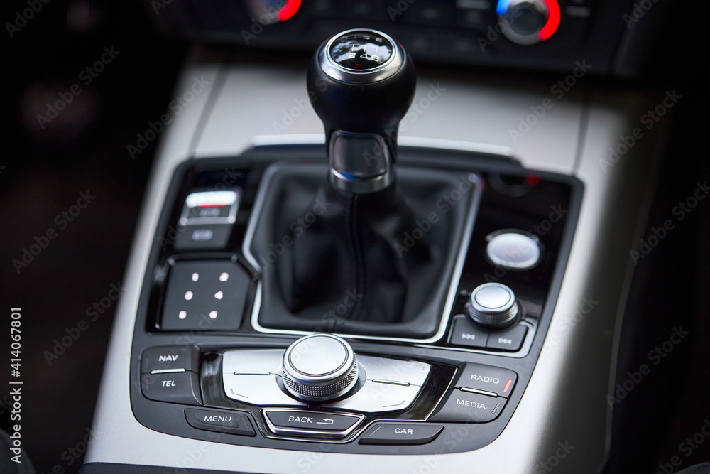 Modern luxury interior shift gear of manual gearbox and Multi Media Interface controls for controlling navigation system sound system and hand held phone of premium automobiles. Modern luxury interior shift gear of manual gearbox and Multi Media Interface controls for controlling navigation system sound system and hand held phone of premium automobiles.