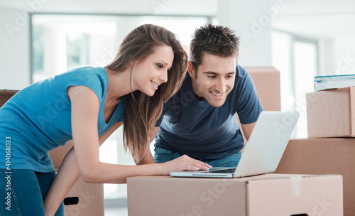 Couple using a laptop in their new house