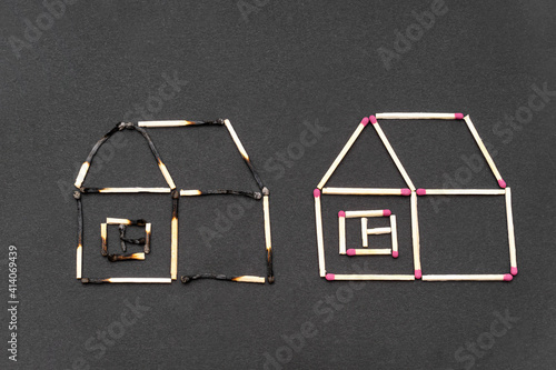 Two match houses made of burnt and unburnt matchsticks on a black background.Creative flat lay composition. Fire insurance coverage concept. photo