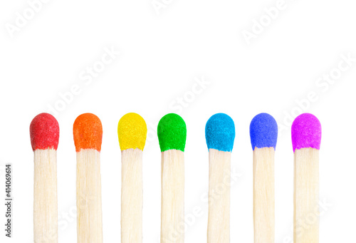 Vertical row of seven matches with match heads painted in rainbow colors isolated on white background.